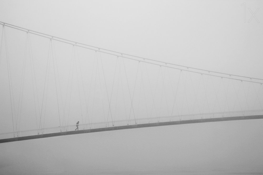 Einsamer Spaziergang auf nebliger Brücke von Krunoslav Nevistic