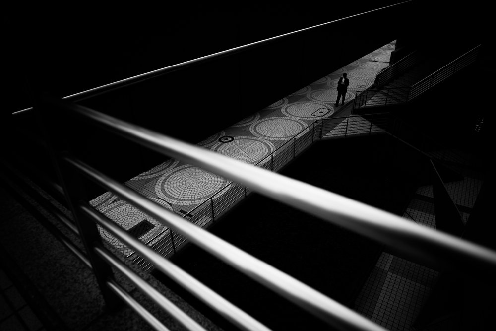 Einsamer Mann auf städtischem Gehweg von Satoshi Hata