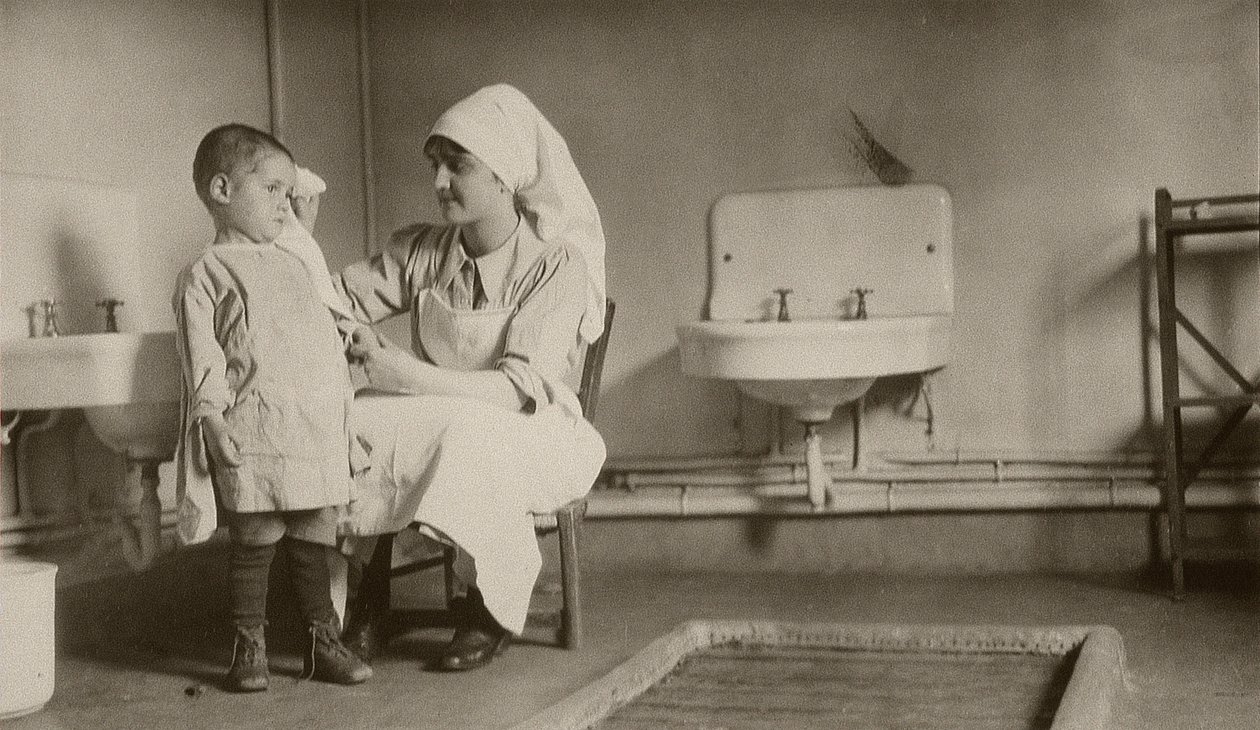 Krankenschwester pflegt ein krankes Kind in den Kolonien von Passay und Saint-Quentin für Flüchtlinge und Waisen, 1919 von American Photographer