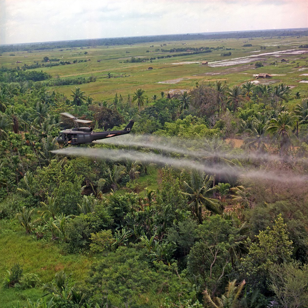 Ein UH-1D-Hubschrauber der 336th Aviation Company sprüht ein Entlaubungsmittel über einem dichten Dschungelgebiet im Mekong-Delta, 26. Juli 1969 von American Photographer