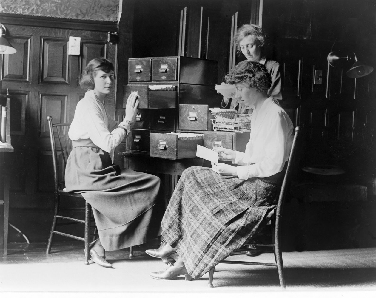 Drei Frauen arbeiten an den Karteikarten im Hauptquartier der National Woman