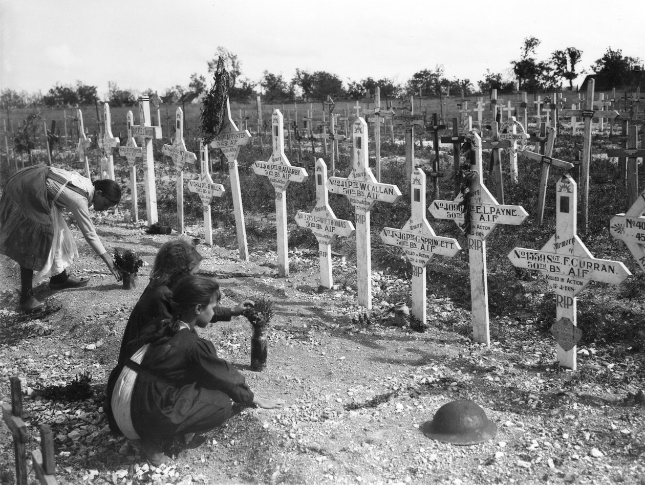 Französische Kinder pflegen Gräber auf dem Adelaide-Friedhof von Australiern, die an der Westfront gefallen sind, Villers-Bretonneux, Frankreich, 26. August 1919 von Australian Photographer