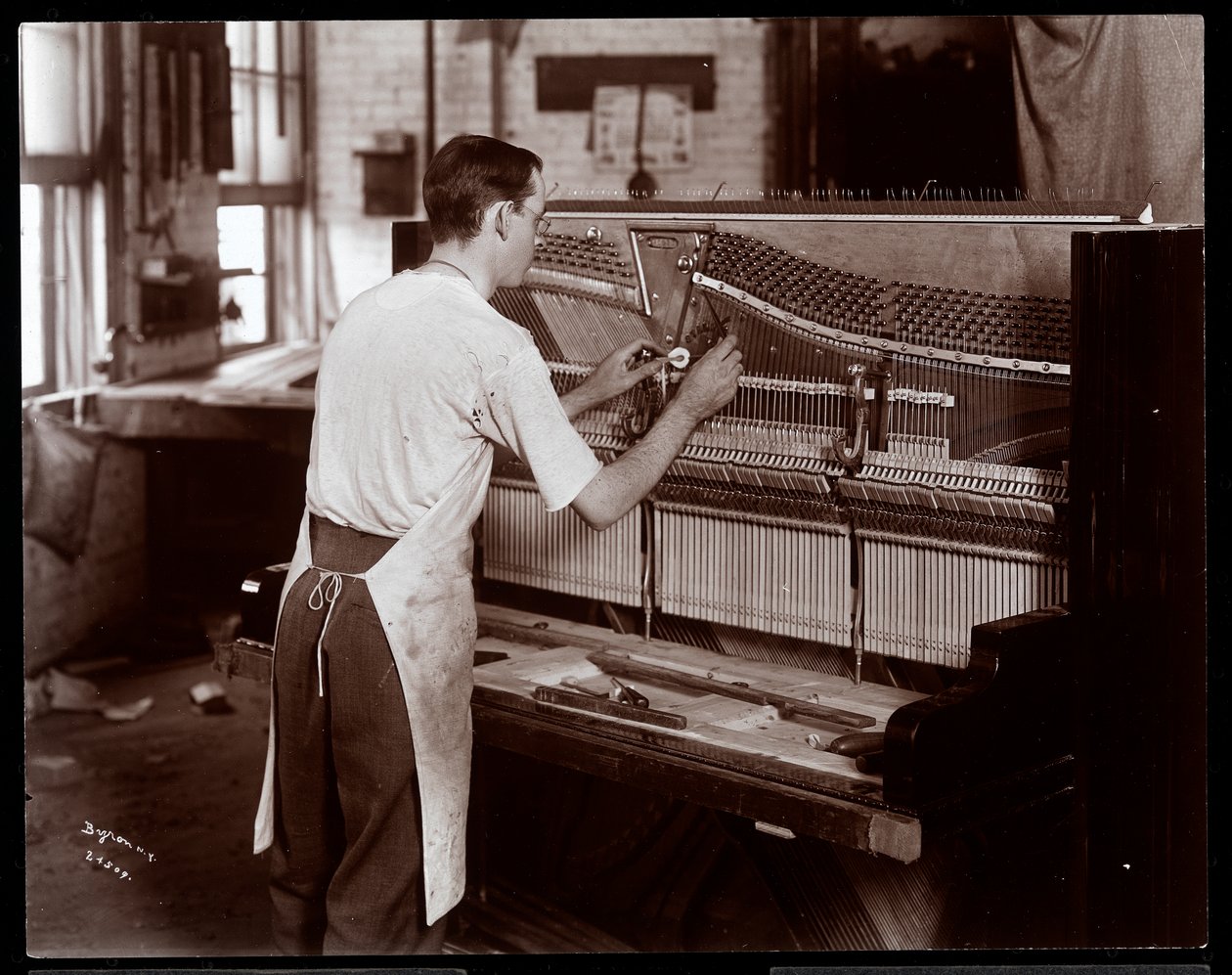 Mann arbeitet in der Hardman, Peck und Co. Klavierfabrik, New York, 1907 von Byron Company