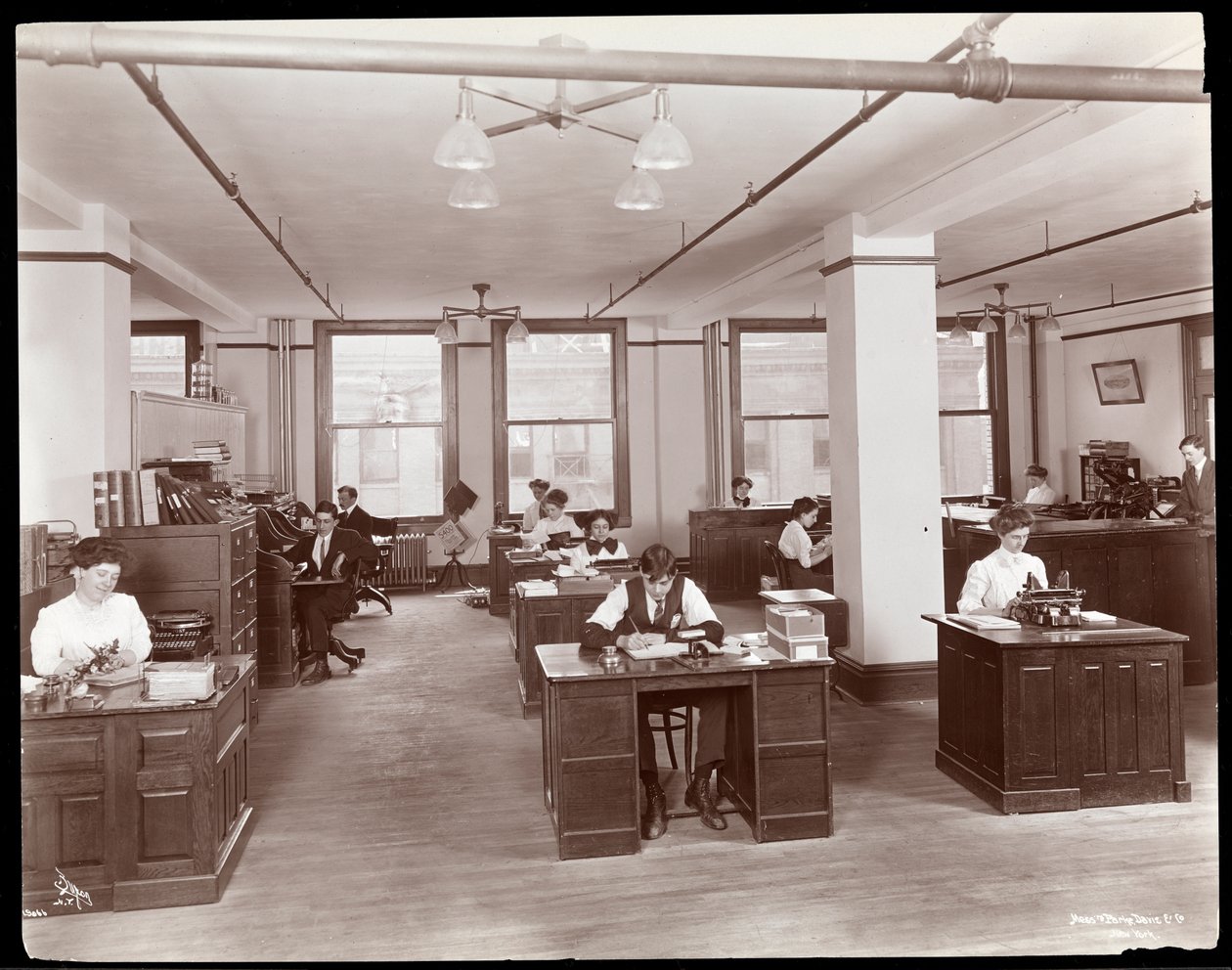 Männer und Frauen in einem offenen Büro bei Parke, Davis und Co., Chemiker, Hudson und Vestry Streets, New York, 1910 von Byron Company