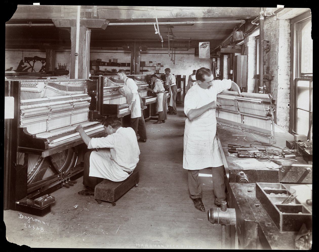 Männer arbeiten in der Hardman, Peck und Co. Klavierfabrik, New York, 1907 von Byron Company