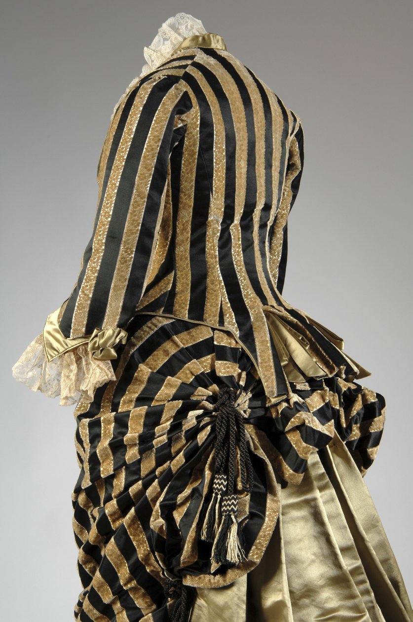Abendkleid, ca.1884 (hintere schräge Teilansicht). Seidensatin und geschnittener Samt, Spitze, Seidenfadenquasten und Fransen. Charles Frederick Worth, Frankreich. von Charles Frederick Worth