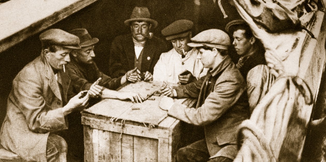 Ein Binnenschiffer und Freunde spielen Domino im Laderaum eines Lastkahns, London von English Photographer