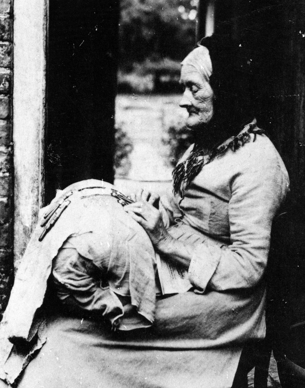 Eine Spitzenmacherin vor ihrem Häuschen in South Buckinghamshire, Ende des 19. Jahrhunderts von English Photographer