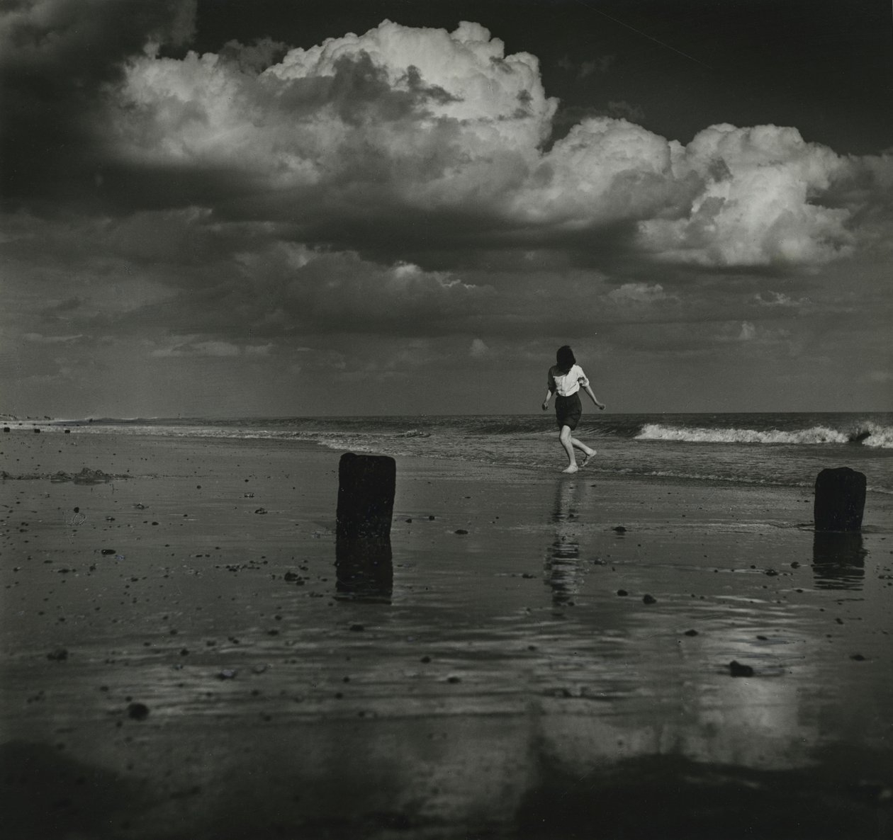 Kind spielt mit den Wellen am Strand von Godfrey Macdominic
