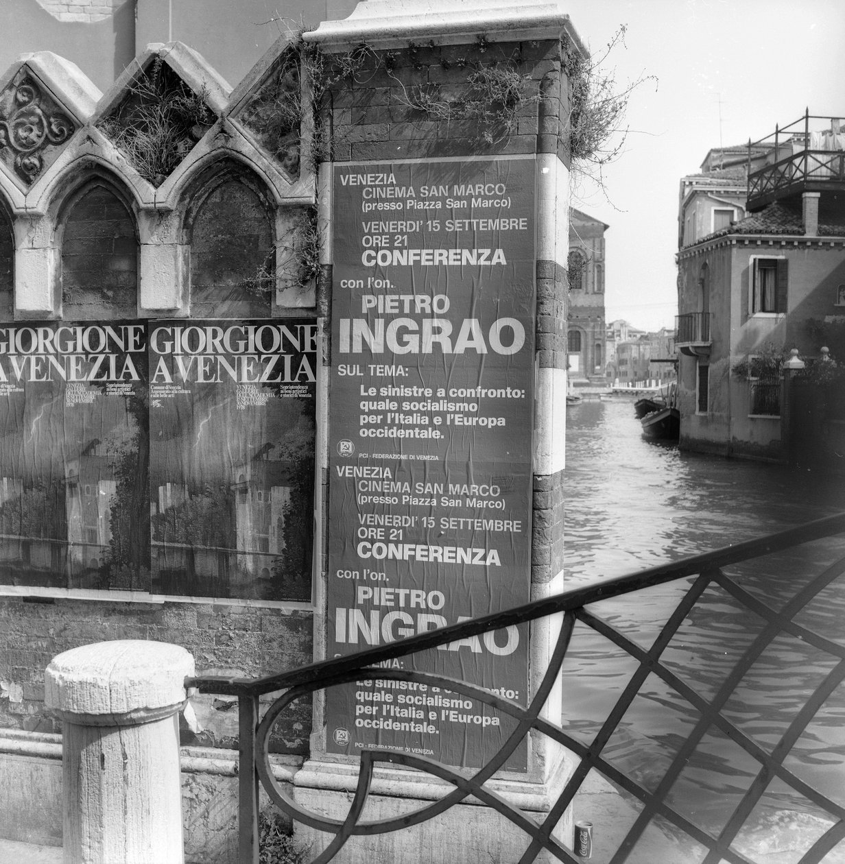 Blick auf einen Kanal in Venedig mit Plakaten, die eine Giorgione-Ausstellung und ein politisches Manifest im Vordergrund bewerben von Italian Photographer