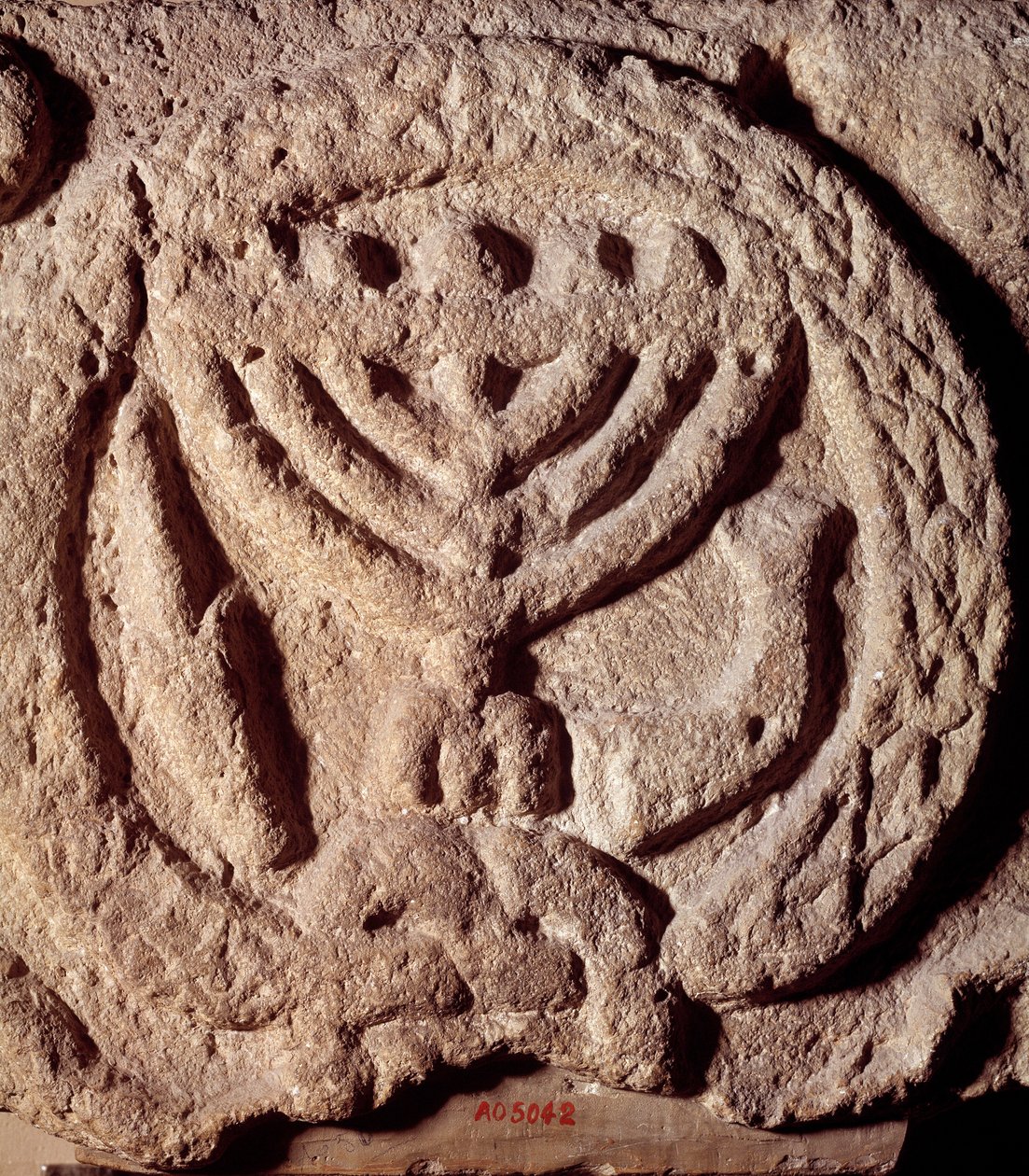 Judentum: Architekturelement aus Basalt einer Synagoge, verziert mit einem siebenarmigen Leuchter (Menora), Palme und Trompete von Jewish School
