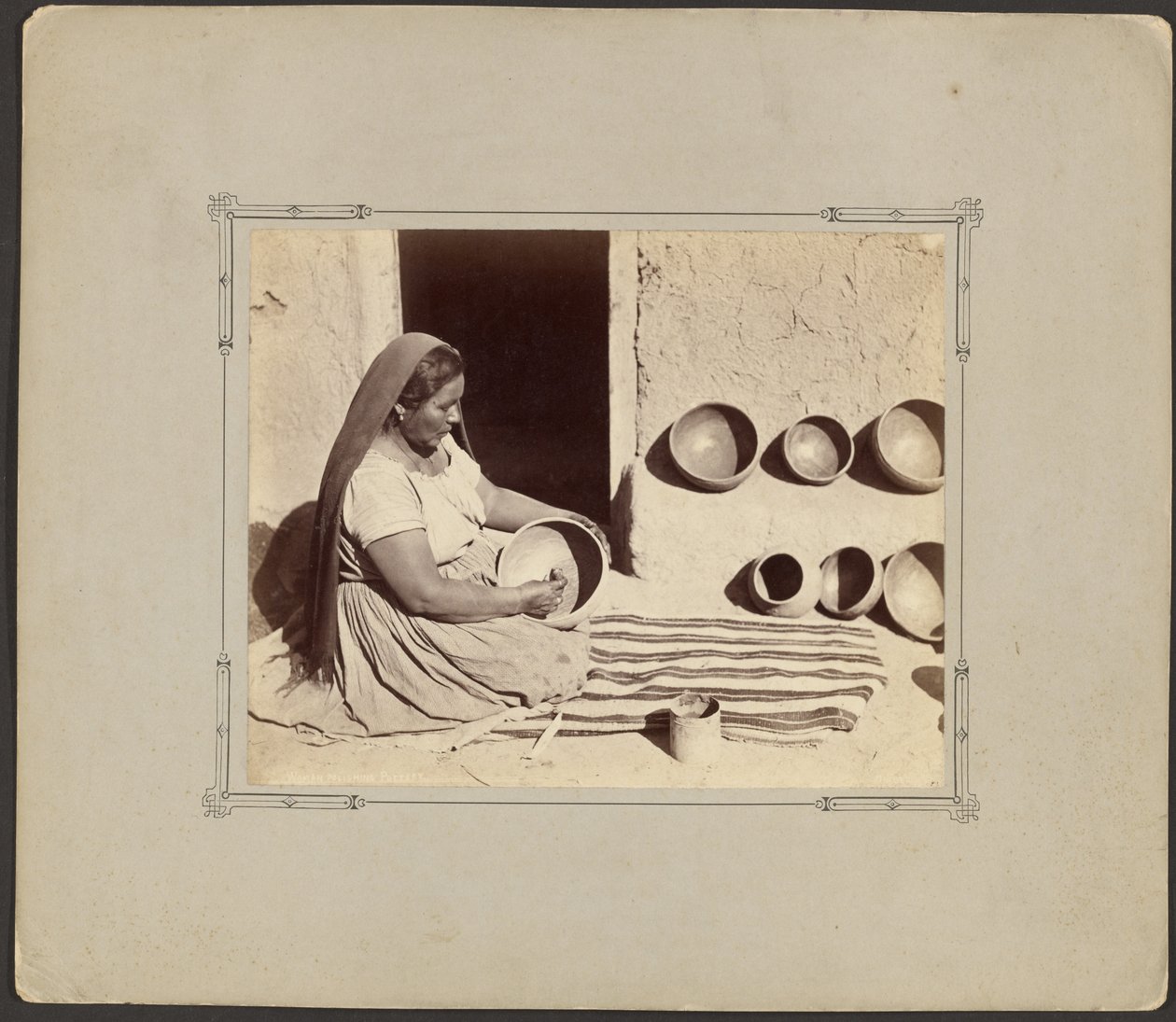 Frau beim Polieren von Keramik von John K. Hillers