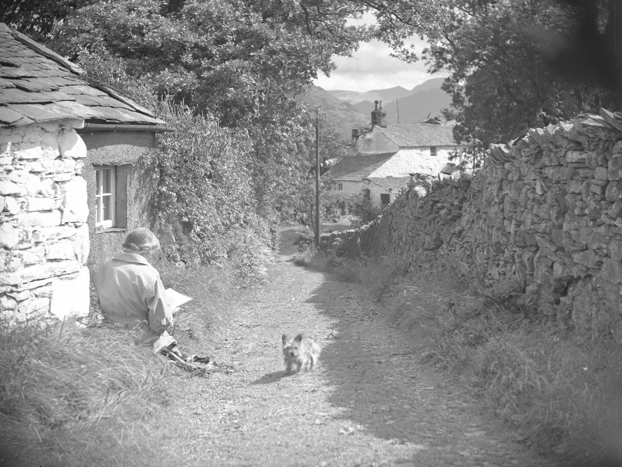 Eine Frau sitzt lesend mit einem Hund in einer Gasse von Joseph Hardman