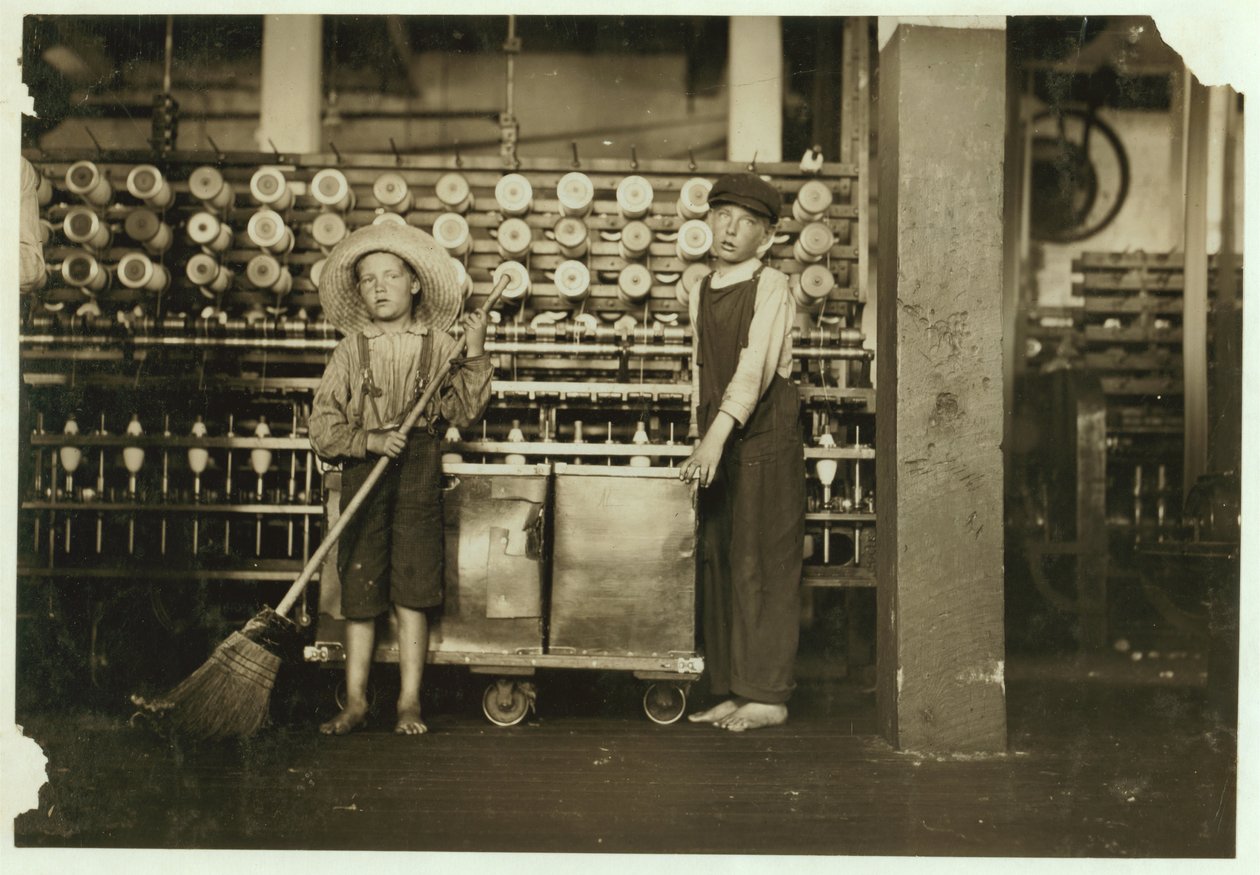 12-jähriger Doffer Ronald Webb und 7-jähriger Frank Robinson, Sohn des Cardroom-Bosses, der fegt und dofft (leert volle Spulen) in den Roanoke Cotton Mills, Virginia, 1911 von Lewis Wickes Hine