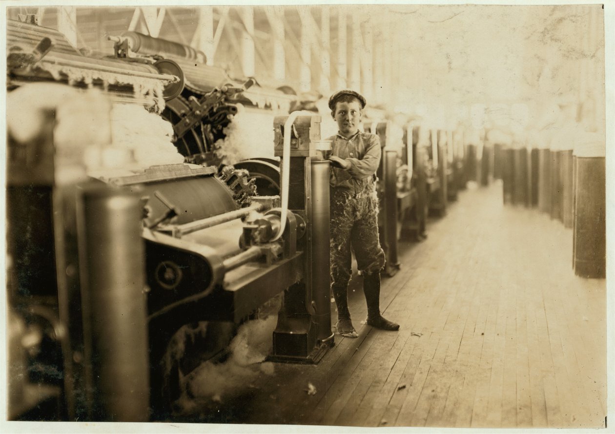 Junge beim Kehren bei Kardiermaschinen in den Lincoln Cotton Mills, Evansville, Indiana, in Strümpfen auf einem rutschigen Boden, 1908 von Lewis Wickes Hine