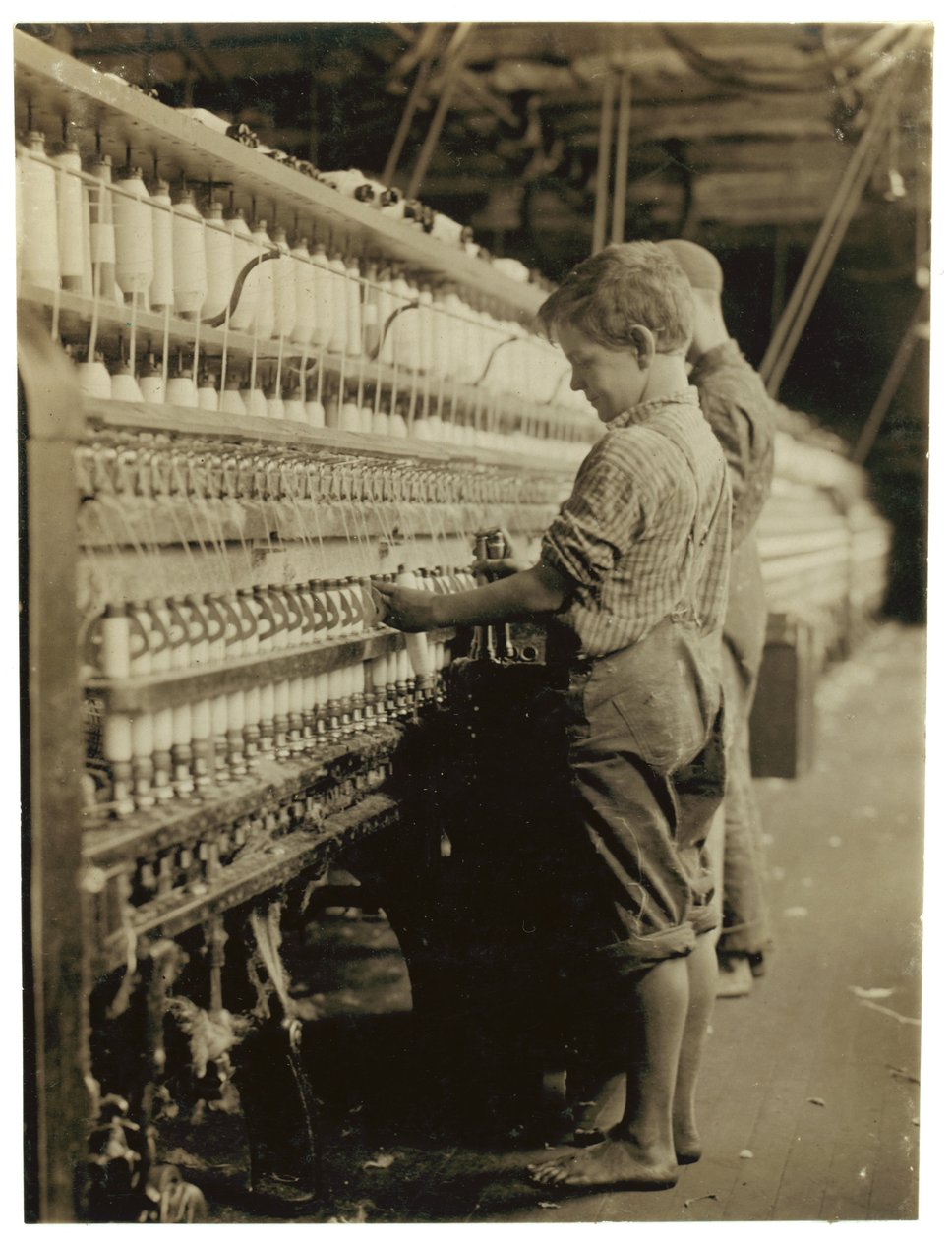 Junge Doffer ersetzen volle Spulen in North Pownal, Vermont, 1910 von Lewis Wickes Hine