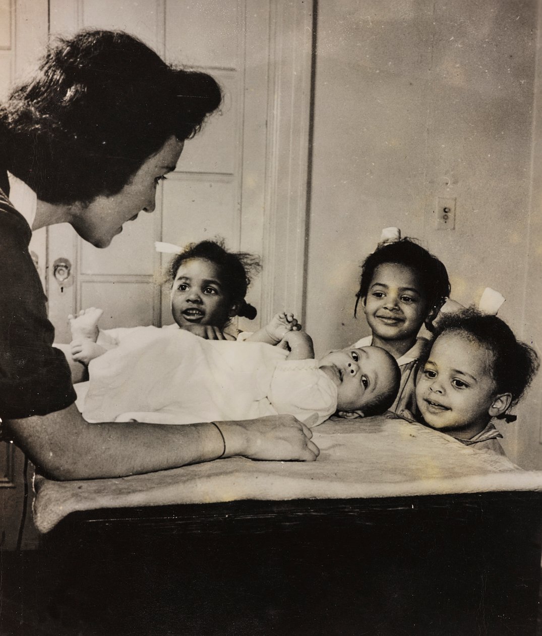 Krankenschwester Henry Street hilft drei afroamerikanischen Mädchen in Harlem, New York City von Luigi Leoni