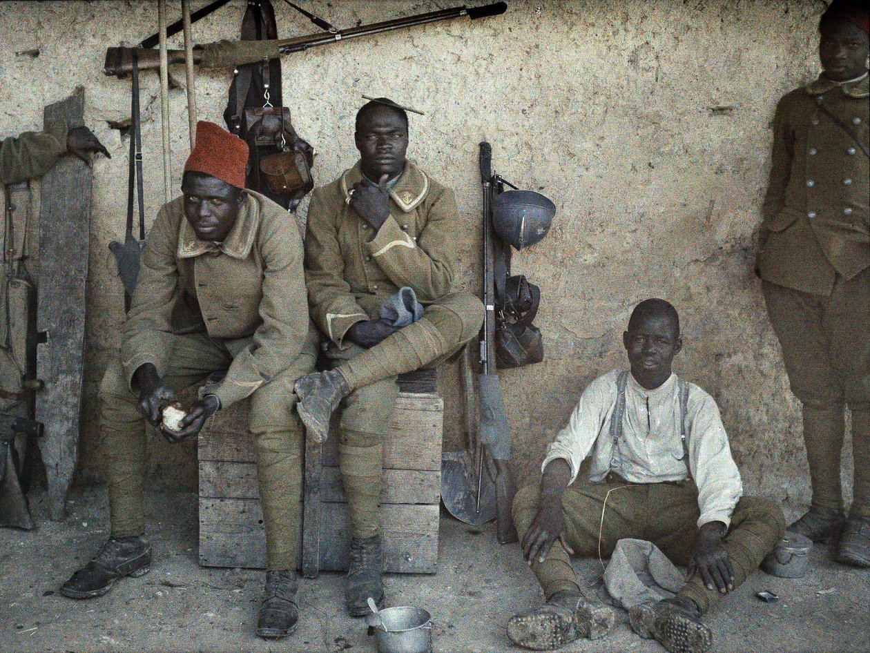 Senegalesische Soldaten, die in der französischen Armee als Infanteristen dienen, ruhen sich in einem Raum mit Gewehren und Ausrüstung aus, Saint-Ulrich, Département Haut-Rhin, Elsass, Frankreich, 16. Juni 1917 von Paul Castelnau