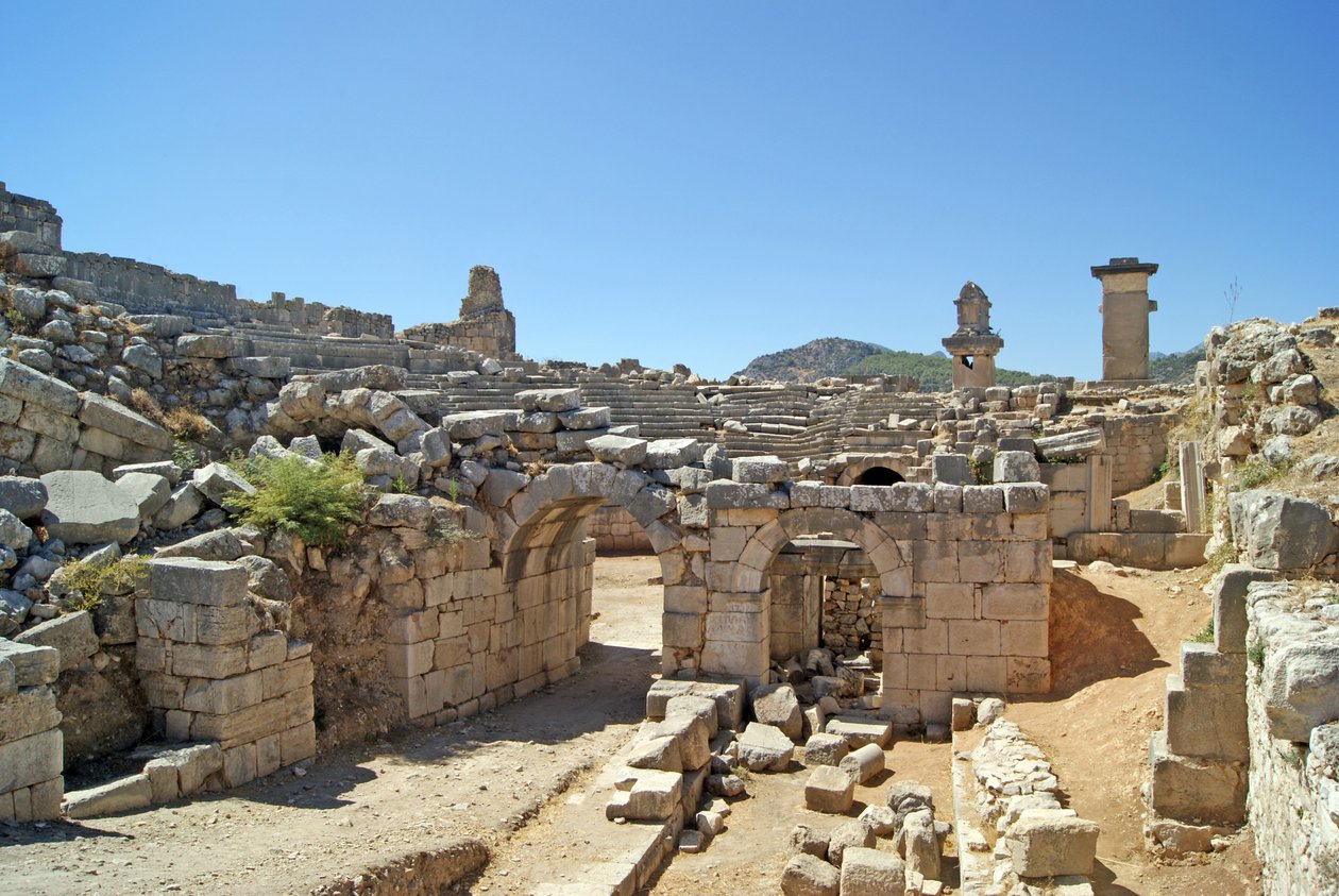 Blick durch den gewölbten Eingang des Theaters von Xanthos in die Orchestergrube, mit Säule und Harpyiengrab, Xanthos, Türkei von Roman
