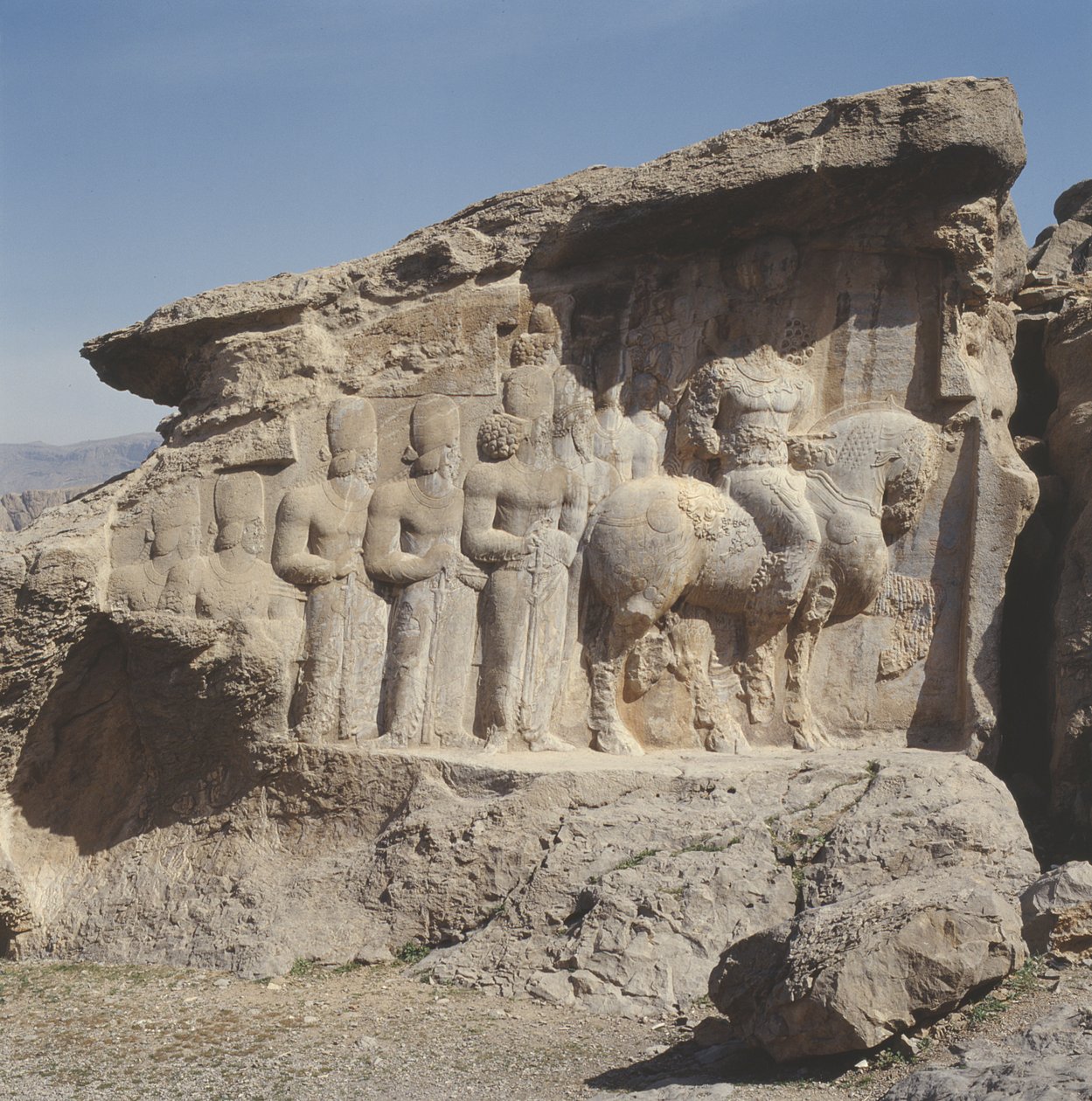 Felsrelief, das Shapur I (AD 241-72) und seine Familie zeigt, die heraldische Embleme auf ihren Hüten tragen, mit einer dreisprachigen Inschrift auf dem Pferd in Griechisch, Parthisch und Mittelpersisch von Sasanian