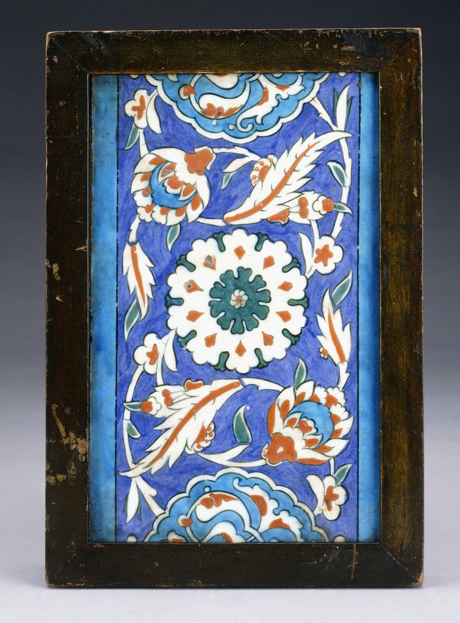 Eine Iznik-Randfliese mit einer zentralen Blütenknospe zwischen rollenden Palmetten und blättriger Ranke, ca. 1570 von Turkish School