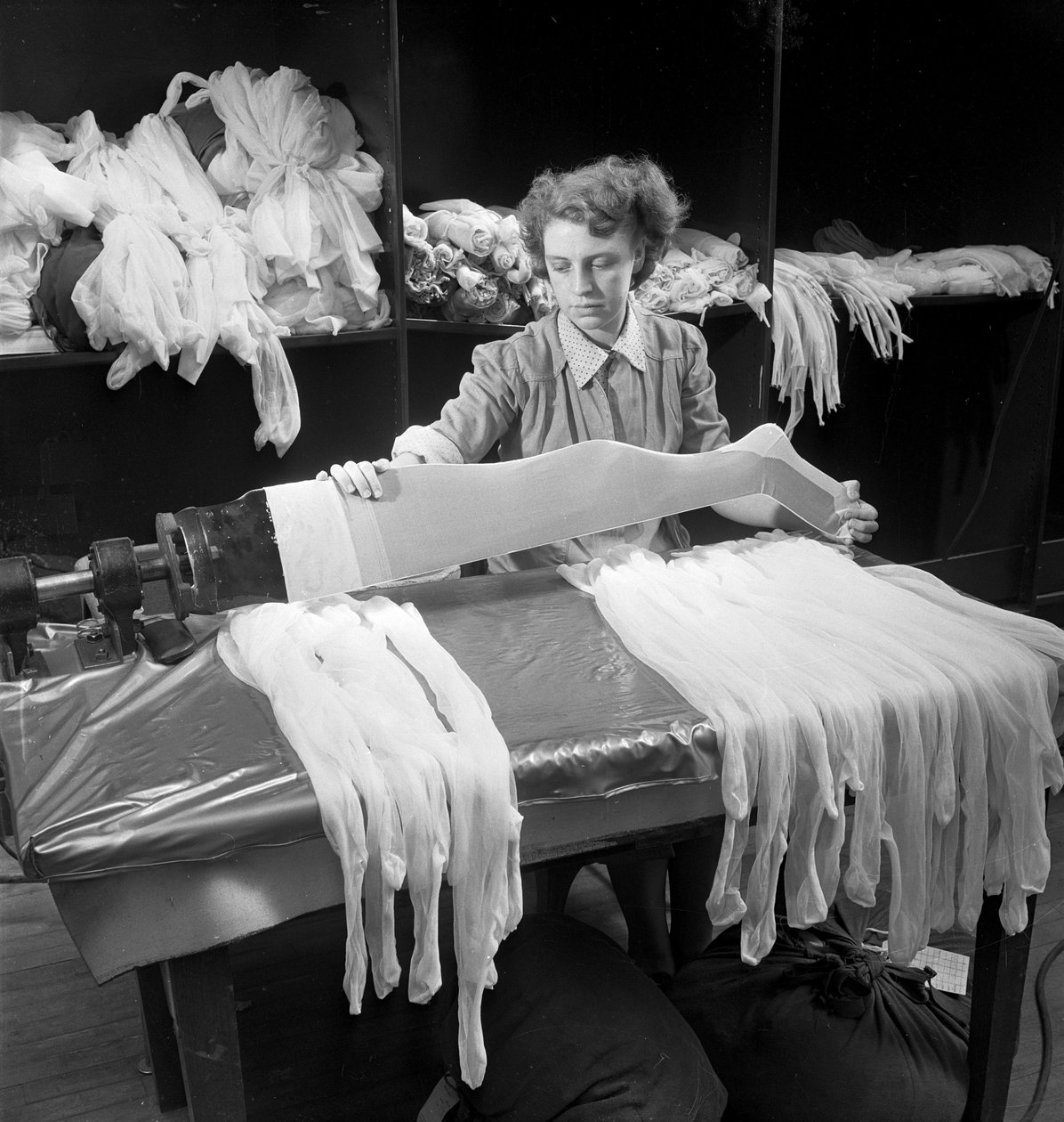 Eine Arbeiterin inspiziert Wollstrumpfhosen in der Aristoc-Fabrik von Unbekannt