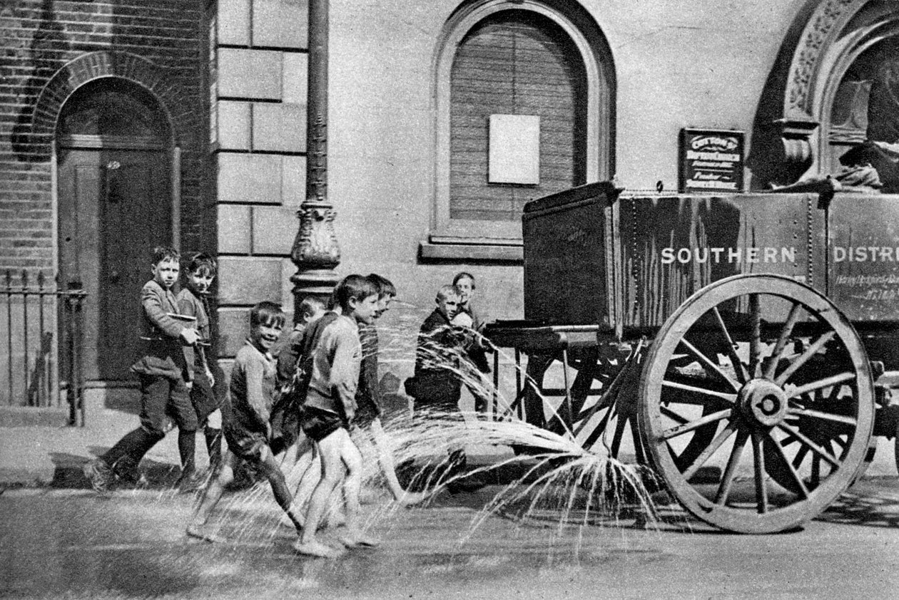 Jungen folgen dem Wasserwagen des Poplar Borough Council, London, 1926-1927 von Unbekannt