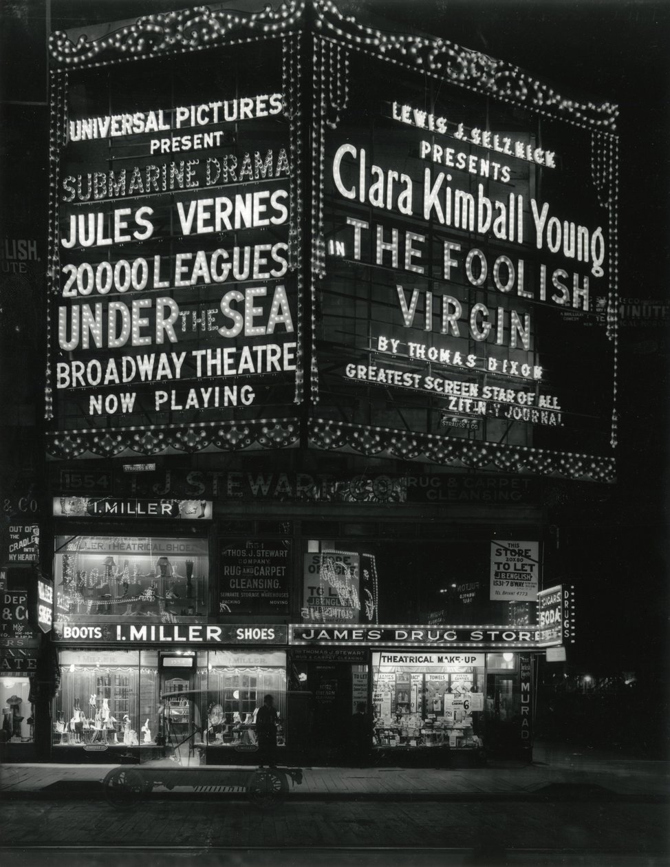 1554 Broadway an der 46th Street, I. Miller Shoes; James Drug Store, und große beleuchtete Kinomarkisen darüber von William Davis Hassler