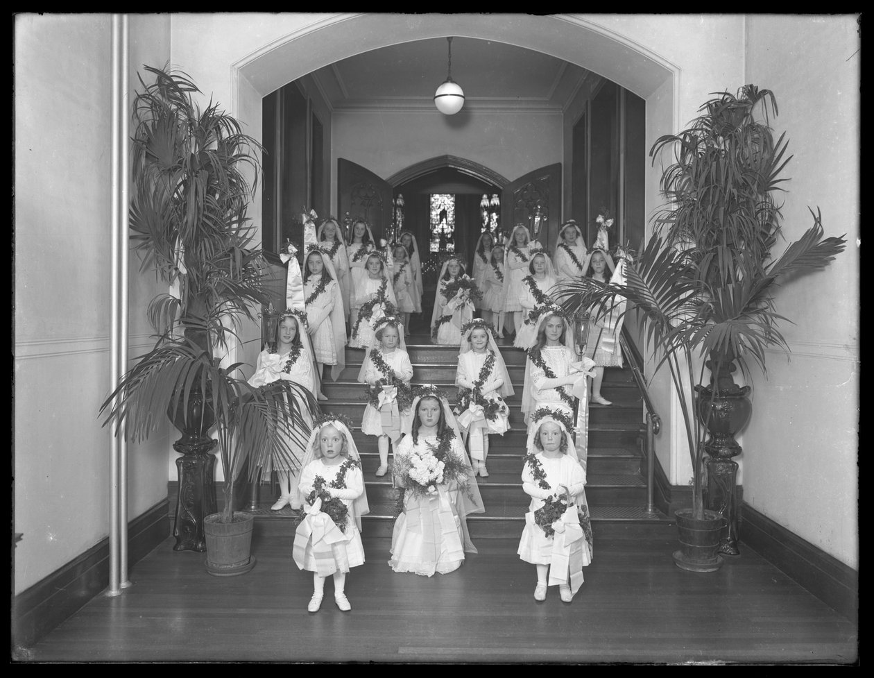 Kleine Mädchen im römisch-katholischen Waisenhaus, Kingsbridge, Bronx, kommen in weißen Kleidern mit Kränzen und Girlanden aus der Kapelle zurück, 20. Oktober 1914 von William Davis Hassler