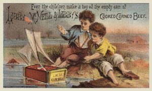 Jungen spielen mit einem Corned Beef Dosen-Segelboot