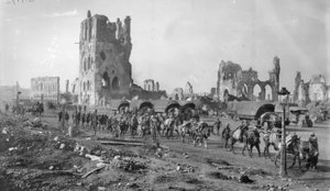 Eine unbekannte australische Maschinengewehrabteilung mit Packpferden passiert die Ruinen der Tuchhalle. Beachten Sie die im Hintergrund geparkten Lastwagen, 19. Oktober 1917