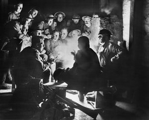 Mitglieder der 1. Australischen Leichten Mörserbatterie, 1. Australische Division, hören die neuesten Nachrichten von einem ihrer Kameraden um ein Feuer in einer Unterstand-Unterkunft in Ypres, 28. Oktober 1917 von Australian Photographer