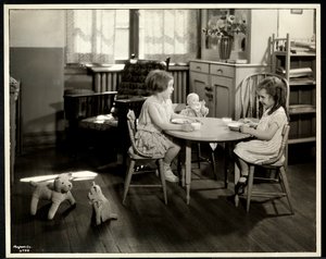 Zwei blinde sehbehinderte Mädchen essen an einem kleinen Tisch mit Puppe bei der New York Association for the Blind, 111 East 59th Street, New York, 1933 (Silbergelatineabzug)