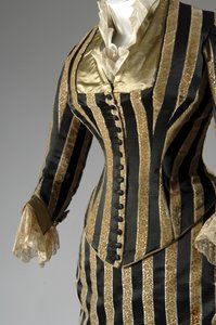 Abendkleid, ca. 1884 (teilweise seitliche schräge Ansicht). Seidensatin und geschnittener Samt, Spitze, Seidenfadenquasten und Fransen. Charles Frederick Worth, Frankreich. von Charles Frederick Worth