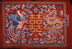 Ein chinesischer Wandbehang aus roter Wolle mit einem zentralen Zeichen in Goldfaden, flankiert von einem Phönix und einem Drachen, 19. Jahrhundert von Chinese School