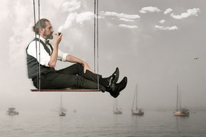 Mann auf einer Himmelschaukel