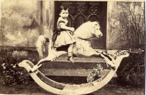 Kleines Mädchen auf einem großen Schaukelpferd im Garten, 1860er Jahre