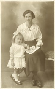 Hübsches Mädchen, Mutter oder Gouvernante, zeigt einem kleinen Kind Fotos von English Photographer