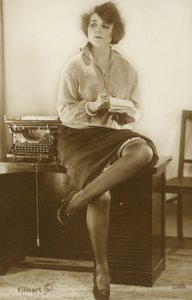 Sekretärin sitzt auf einem Schreibtisch von English Photographer