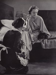 Frau wird morgens von ihrer Zofe beim Ankleiden geholfen, Mayfair, London von English Photographer