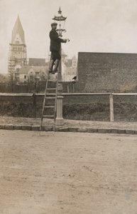 Mann auf einer Leiter repariert eine Straßenlaterne