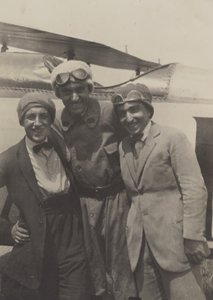 Porträt von drei Männern, die vor einem Flugzeug lächeln