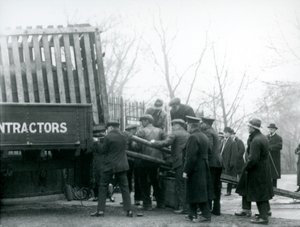 Eine Menschenmenge beobachtet, wie ein Nashorn von einem Lastwagen entladen wird, London Zoo, 1924 von Frederick William Bond