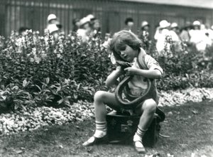 Ein junges Mädchen Betty hält eine östliche Indigo-Schlange, während sie auf einem Lederkoffer sitzt, London Zoo, 1924