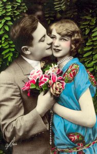 Mann, der Blumen trägt, küsst hübsches Mädchen auf die Wange von French Photographer