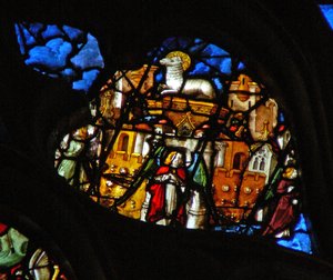 Das Westrosenfenster zeigt eine Szene aus dem Buch der Offenbarung: Neues Jerusalem, gefärbt mit Feingold, ein Engel an jeder Tür, mit allen Arten von Steinen in den Mauern und das Lamm auf dem Thron in seiner Mitte.