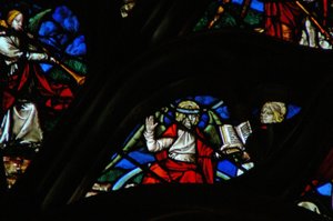 Das westliche Rosenfenster zeigt eine Szene aus dem Buch der Offenbarung: ein Engel (auf einem Regenbogen) gibt Johannes ein offenes Buch (10:1,8). von French School