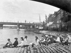 Kinder auf dem gepflasterten Damm unter der Southwark-Brücke, London, ca. 1930 von George Davison Reid