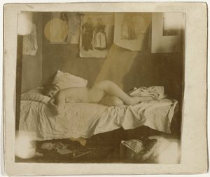 Marie Jordan nackt auf einem Bett liegend