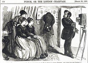 Karikatur, die einen pompösen Porträtfotografen zeigt, der das Unmögliche vom Subjekt verlangt von George du Maurier